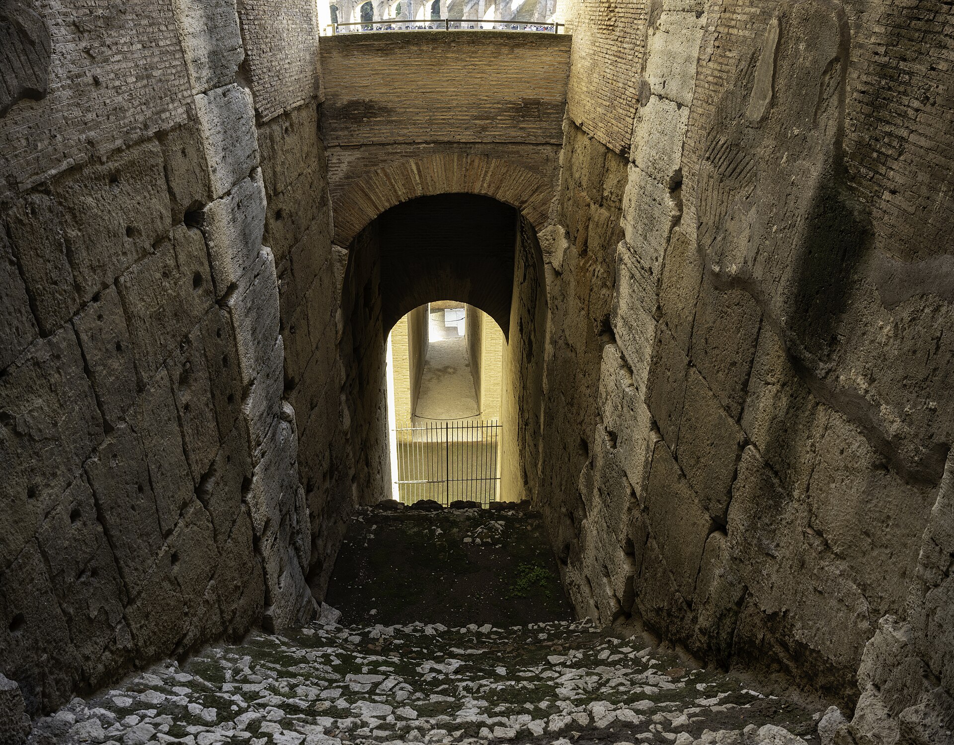 The Colosseum in Rome seen from outside in daylight, its curved walls of arched stone in three tiers, partly ruined on one side