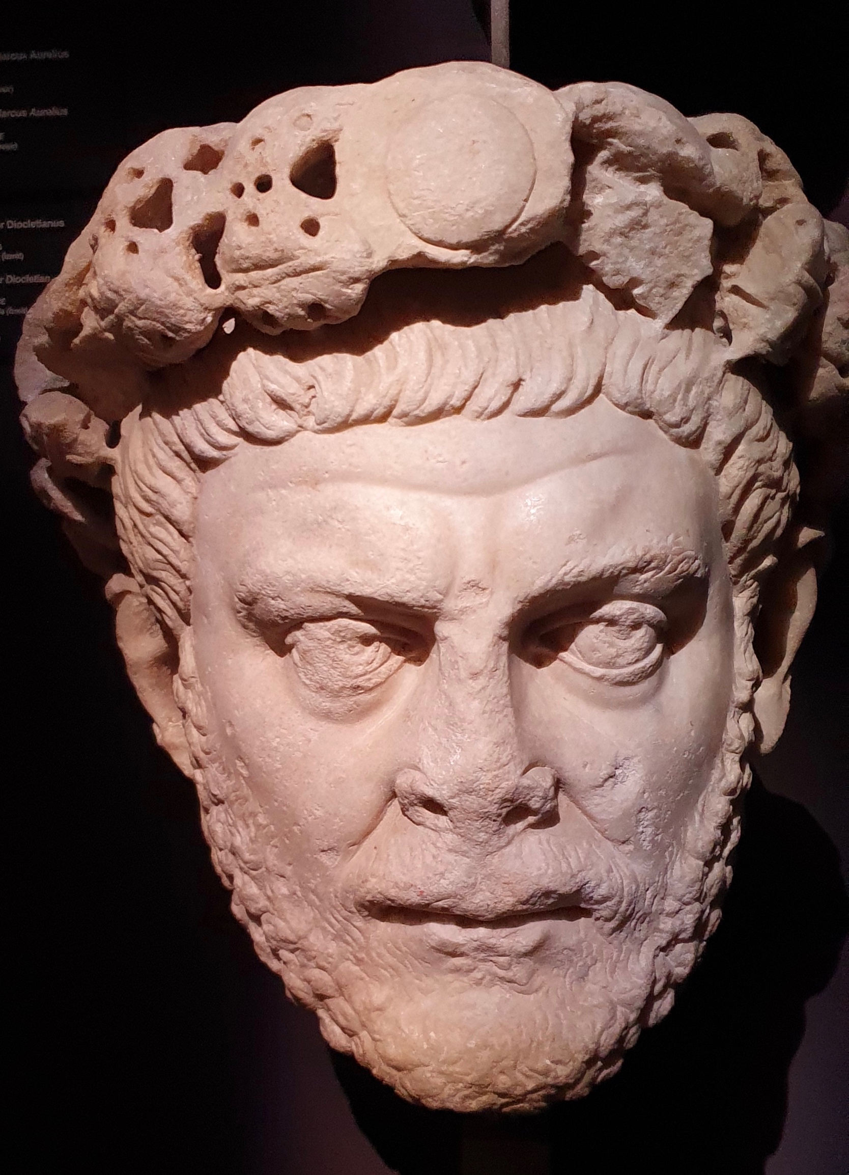 Marble portrait bust of a short-haired, clean-shaven Roman man with a furrowed brow