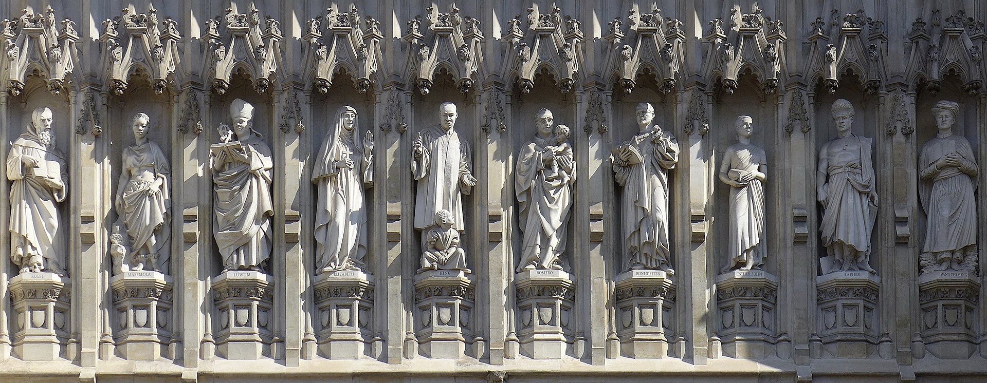Row of ten stone statues in niches above the great west door of Westminster Abbey