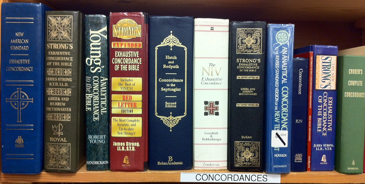 Several thick printed Bible concordances of different sizes and bindings arranged together