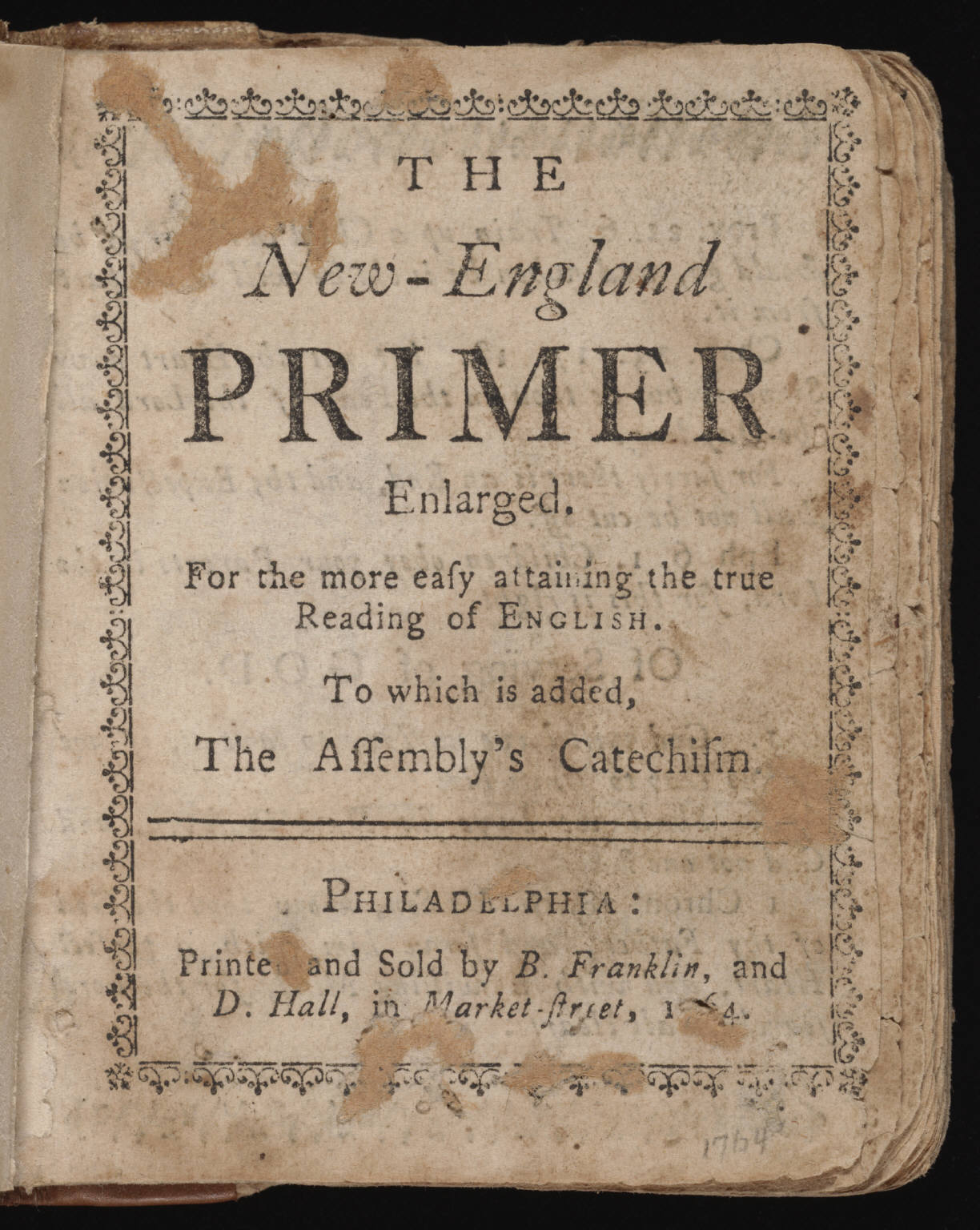 Small printed page with a woodcut portrait at top and the title The New-England Primer Enlarged in decorative type, with a Philadelphia imprint at the bottom