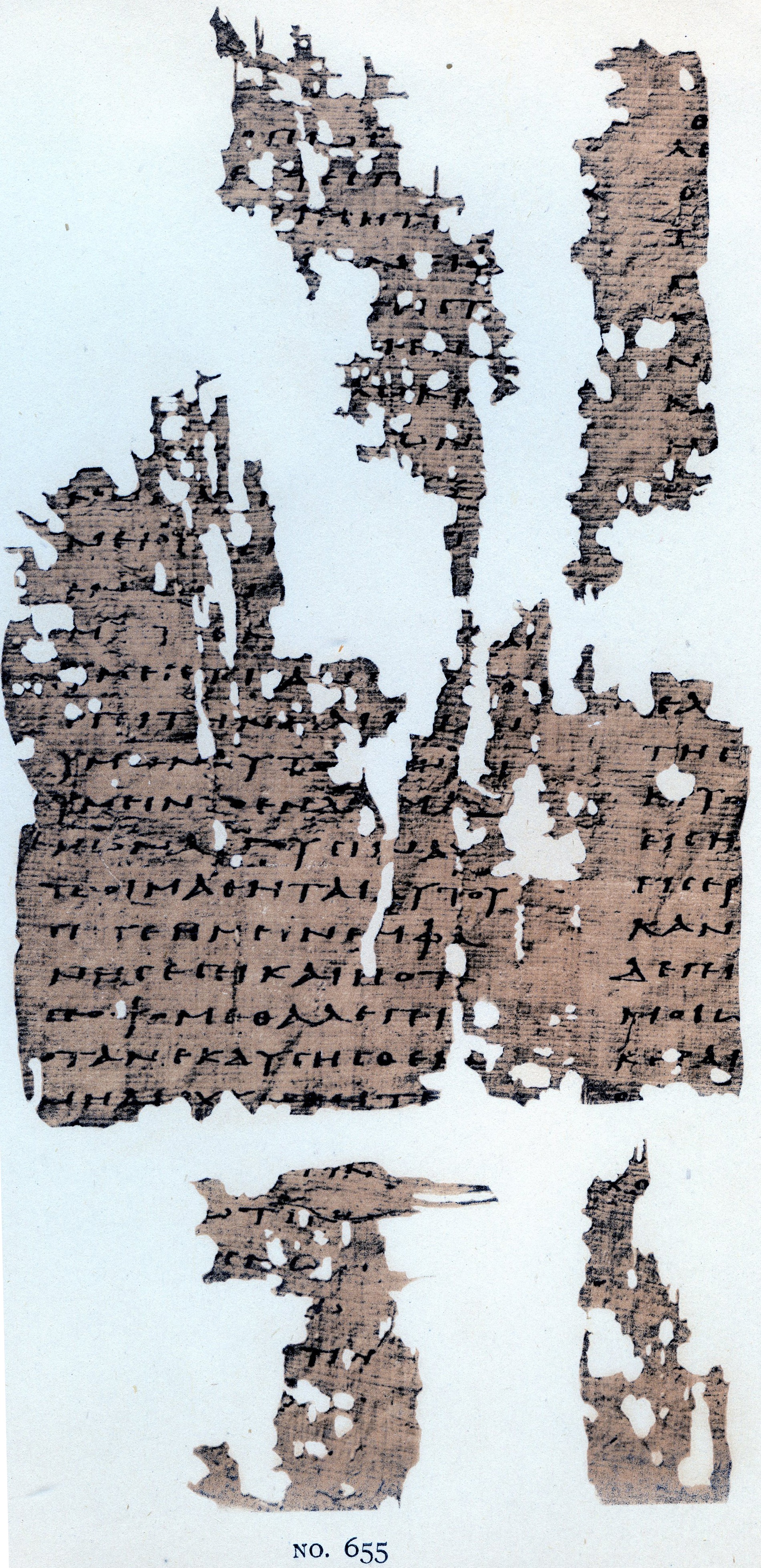 Several dark brown papyrus scraps mounted together, with faint lines of Greek letters