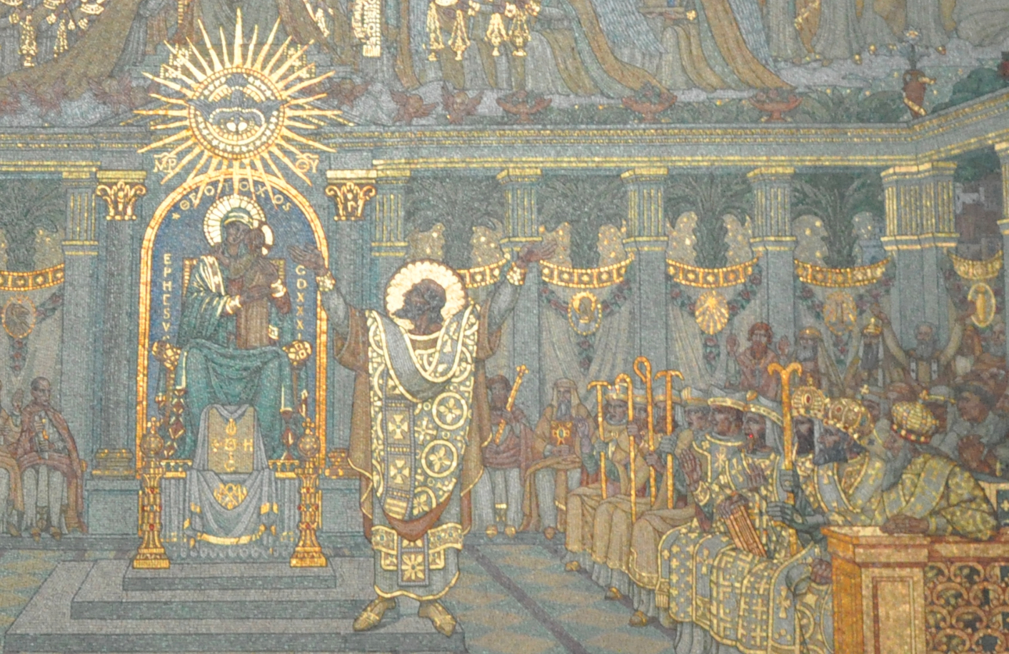 A detail of a large wall picture made of small colored stones: bishops in white and gold vestments with croziers stand in a hall, with the Virgin Mary and the dove of the Holy Spirit above them on a gold ground.