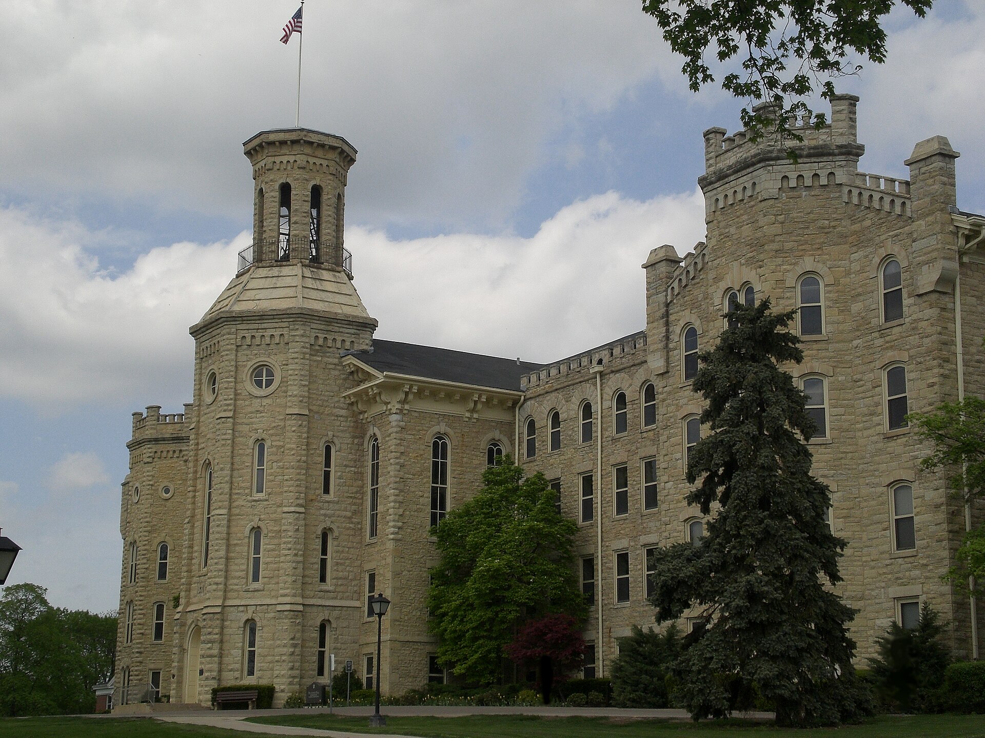 The stone Gothic Revival tower and front of Blanchard Hall at Wheaton College in Illinois, with lawn and trees