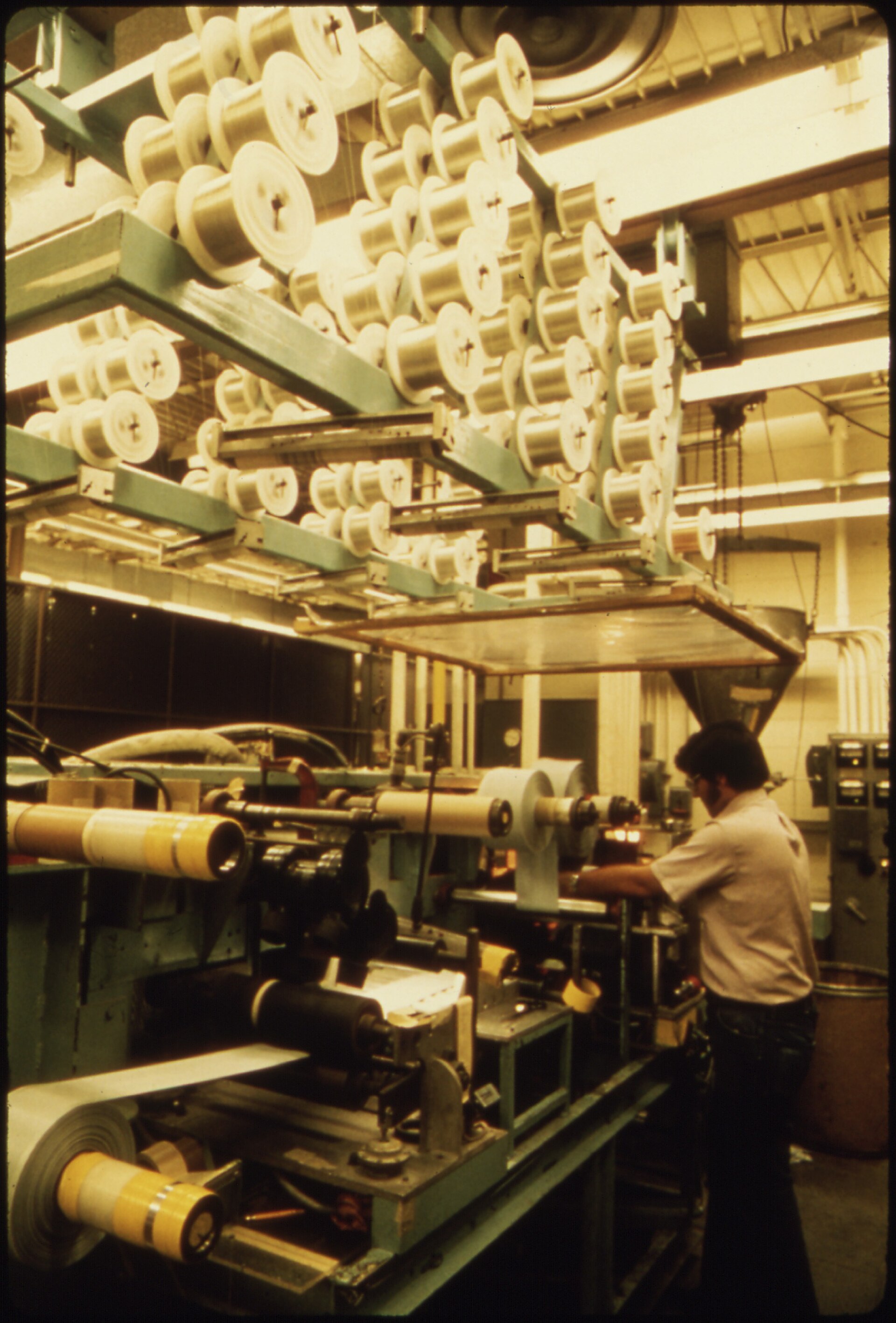 Black and white photograph from 1974 of an employee working at one of the machines inside the 3M Company plant in New Ulm, Minnesota.