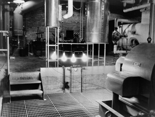 Four lit incandescent light bulbs hanging in a row inside the EBR-I reactor building