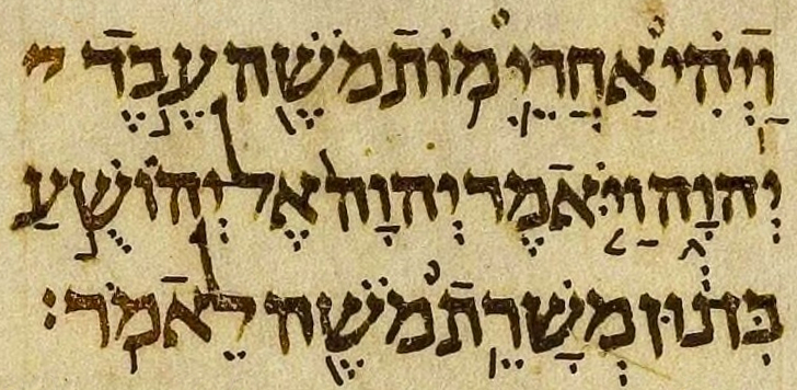 A page of the Aleppo Codex in three columns of Hebrew, with small vowel and accent marks around the letters and notes in the margins