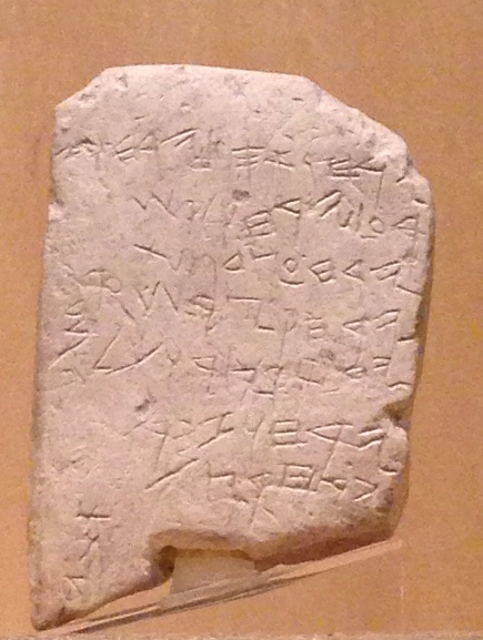 A small limestone tablet carved with seven lines of early alphabetic letters, the Gezer calendar
