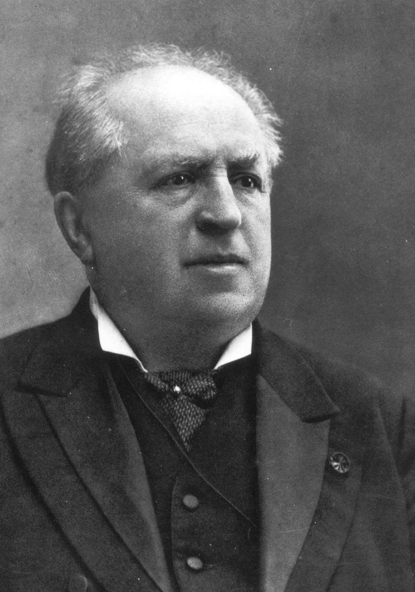 Photograph of Abraham Kuyper, an older man with a full white beard and moustache, in formal dress