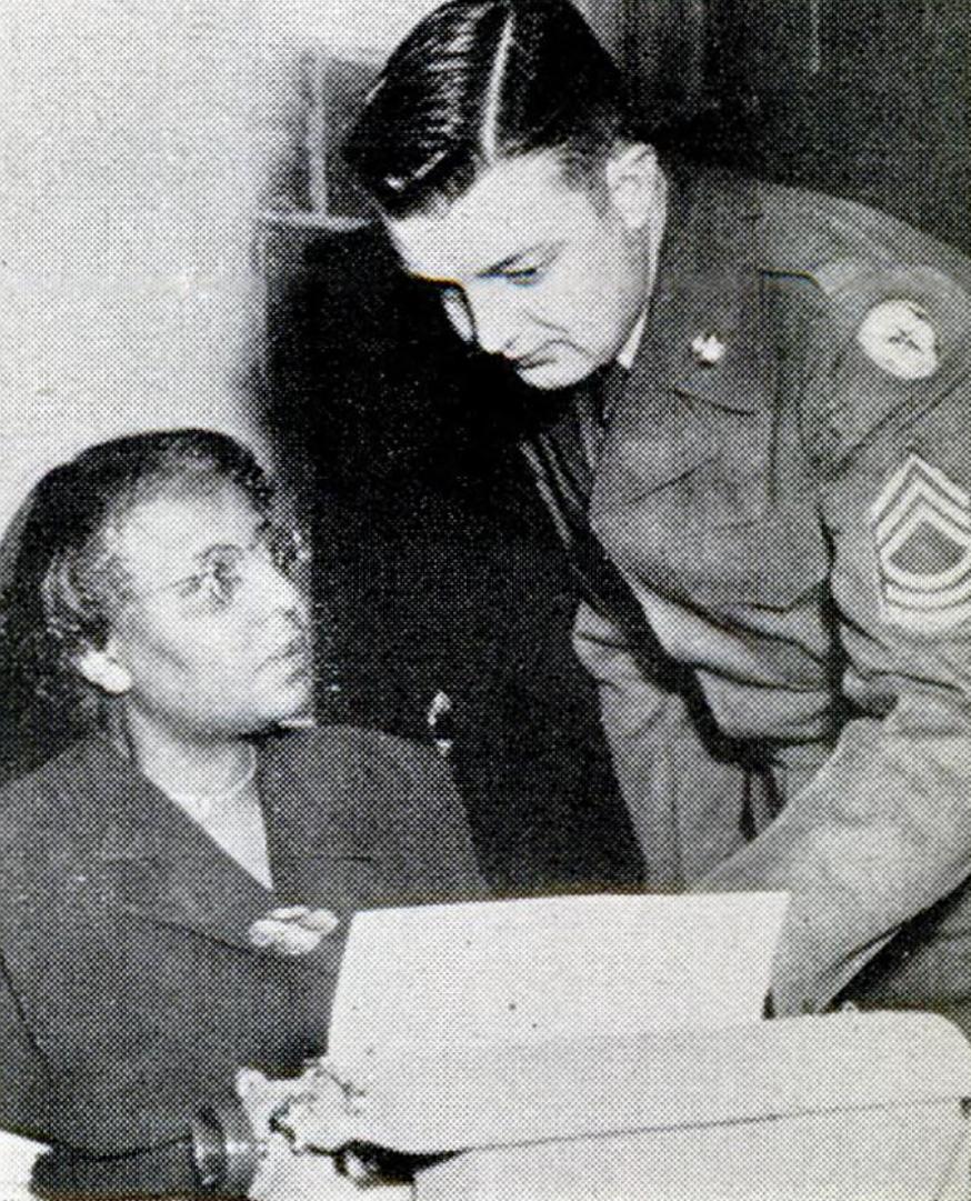 A woman seated with a man who is briefing her