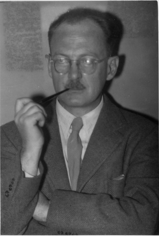 Black and white head and shoulders portrait of Owen Lattimore, a middle-aged man in a suit and tie