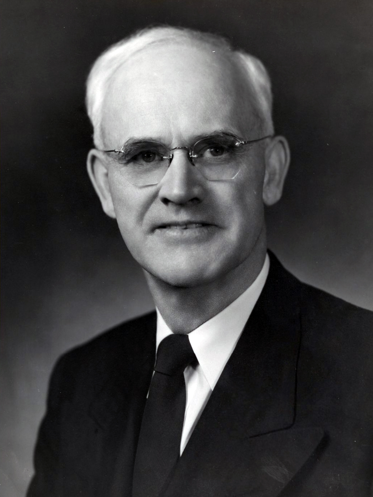 Formal portrait photograph of a man in a suit