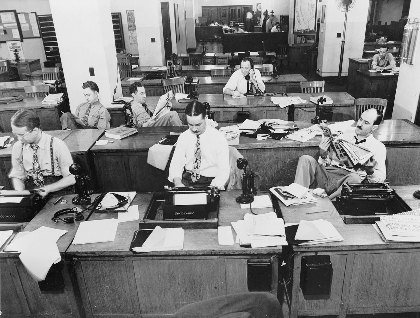 Reporters and rewrite men at desks in the New York Times newsroom in 1942, one on the phone